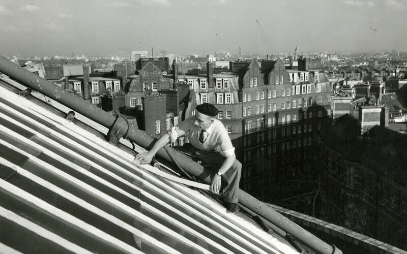 a worker undertaking post-war renewal work on the roof at the Royal Albert Hall