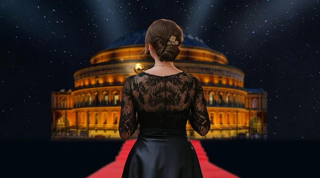 Woman standing on a read carpet looking at the Royal Albert Hall against a starry sky