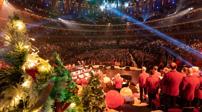 Photo taken from behind The Salvation Army performing at the Royal Albert Hall with a Christmas tree in the foreground