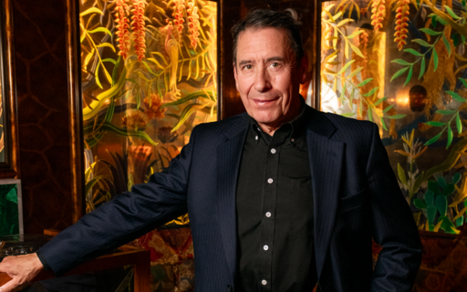 Jools Holland standing in front of a floral background