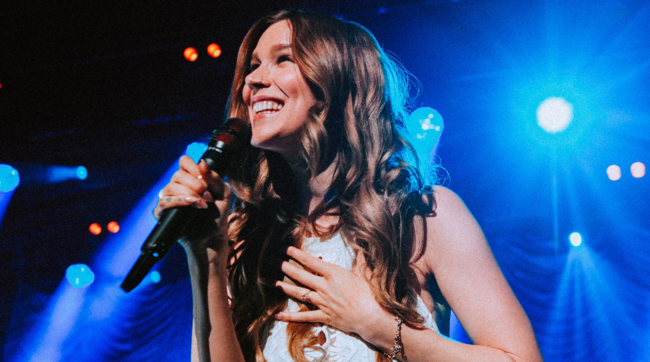 Joss Stone holding a microphone on stage
