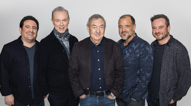5 men standing in a row in front of a grey background