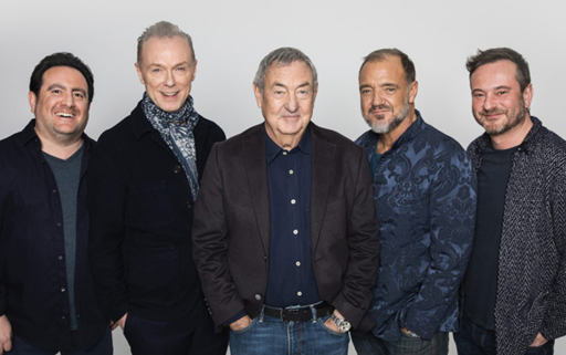 5 men standing in a row in front of a grey background